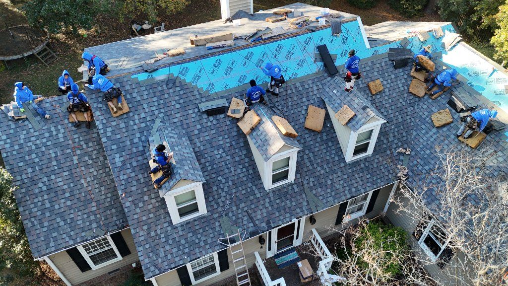 A Fortitude crew on a beach house roof during a replacement, with the ocean behind them